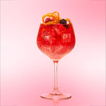 Do'Mo Scrumptious Berry Bramble served in a balloon glass with lemon rind garnish and fresh fruit.